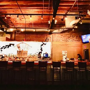 a bar with a large screen in the background