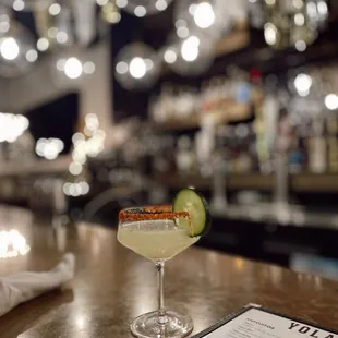 a margarita with a cucumber garnish