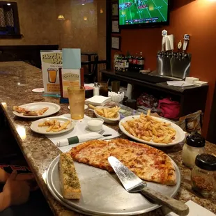 pizza and french fries on a table