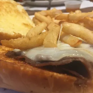 Piece of chipped or shaved beef of some kind, slice of white cheese and some fries on a ginormous bun. Save your money ppl