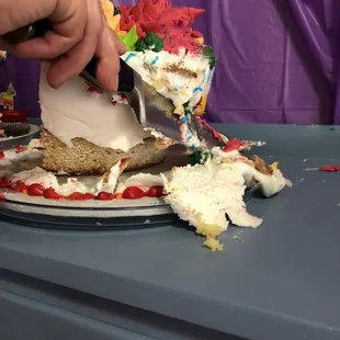 a person cutting a piece of cake