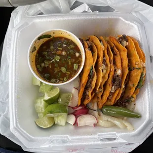 a tray of tacos and a bowl of salsa