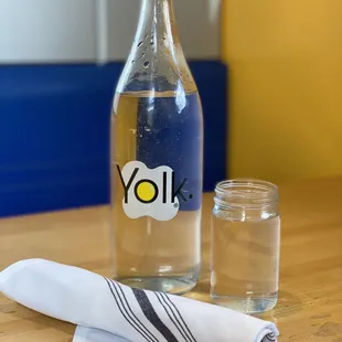 a glass of water and a bottle of yolk