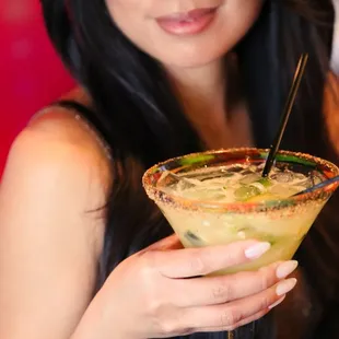 a woman holding a margarita