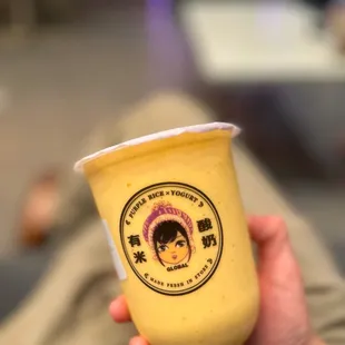 a person holding a cup of yogurt