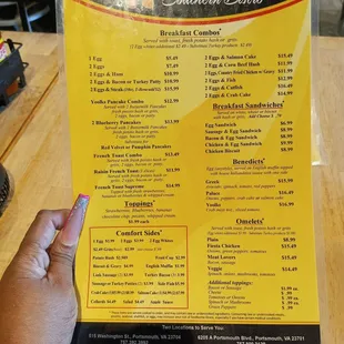 a hand holding a menu