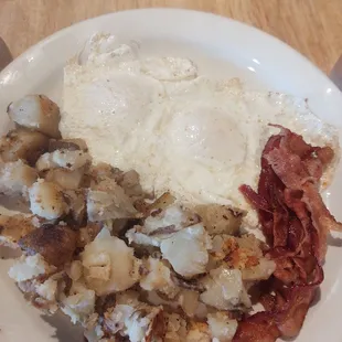 Eggs over easy bacon and potatoes