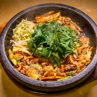 dolpan ojinge- squid and vegetables over rice in sizzling stone plate with spicy sauce