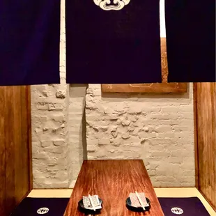 a wooden table with blue mats and chopsticks on it