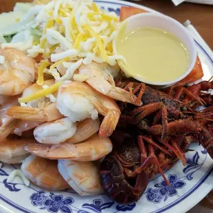 a plate of shrimp, lobster, and coleslaw