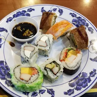 a plate of sushi with dipping sauce