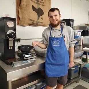a man standing in front of a coffee roaster