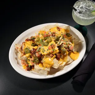 a plate of nachos and a drink