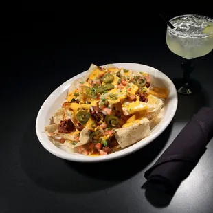 a plate of nachos and a drink