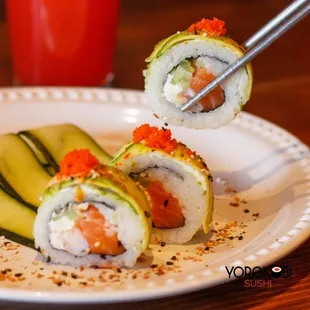a plate of sushi with cucumbers and pickles