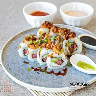 a plate of sushi with sauces