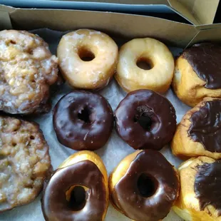 Clockwise from left: Apple fritters, glazed, chocolate glazed cream filled, chocolate glazed, double chocolate cake donuts.$8.39/dozen