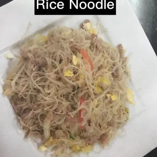 a plate of rice noodles with meat and vegetables