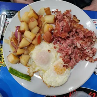 Corned beef hash and eggs over medium with country potatoes