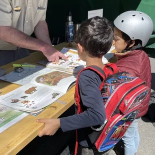 Ranger Eric Nelson and my friend's son getting his Junior Ranger Badge :')