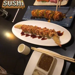 a plate of sushi with chopsticks
