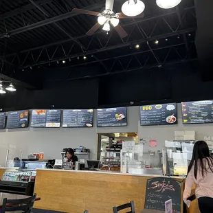a woman standing at a counter in a restaurant