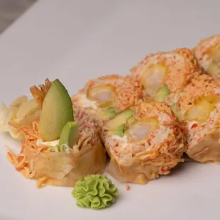 a plate of sushi rolls with avocado
