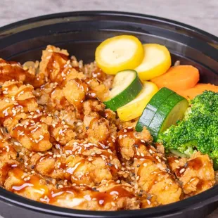 a bowl of food with broccoli, carrots, and zucchini