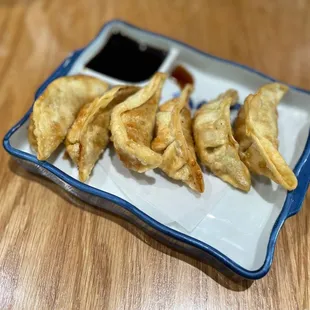 a plate of wontons with dipping sauce