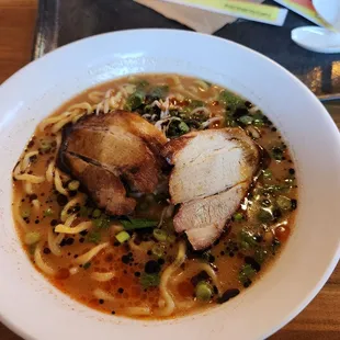 a bowl of ramen with meat and vegetables