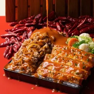 a plate of meat with sauce and vegetables