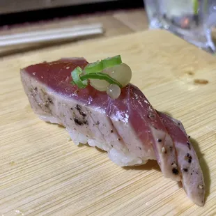 a piece of sushi on a cutting board