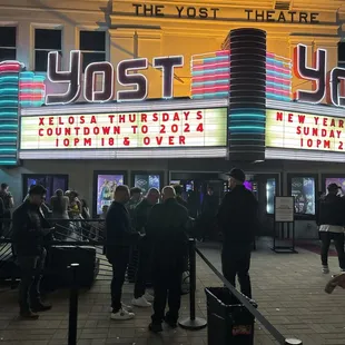 people standing in front of the theater