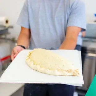 ows a man holding a pizza