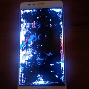 The phone after their repair. Screen was perfectly readable before, now almost completely purple/black.