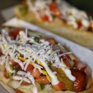 two hot dogs with toppings