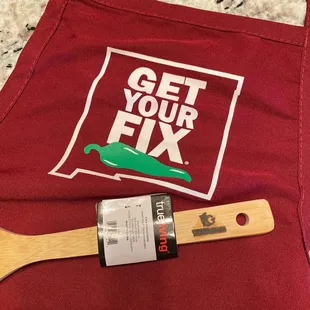 a red apron with a wooden spatula