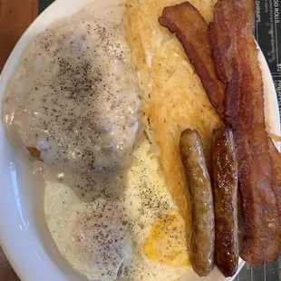 Country fried steak with sausage gravy and a side of bacon and sausage