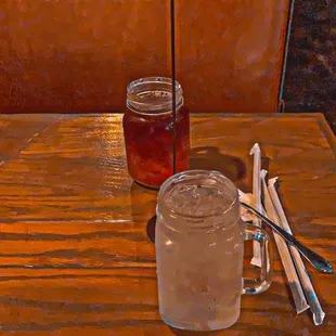 a table with a jar of honey and spoons