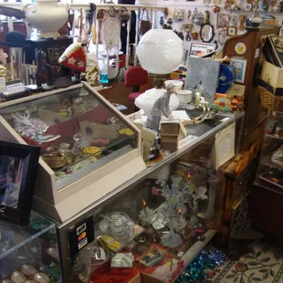 Front desk &amp; register - lots of cool stuff in &amp; on top of the cabinets!