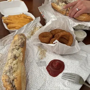 Philly cheesesteaks with onions and white american cheese. Onion rings and cheese fries.