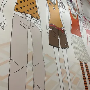 a woman and a man standing in front of a wall mural