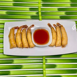 a plate of spring rolls with dipping sauce
