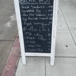 a breakfast menu on the sidewalk