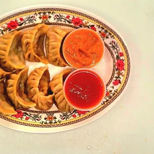 a plate of dumplings and dipping sauce