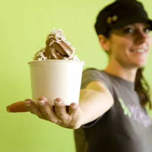 a woman holding a cup of yogurt