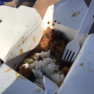 a take out box with rice and meat