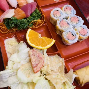 a tray of sushi and vegetables