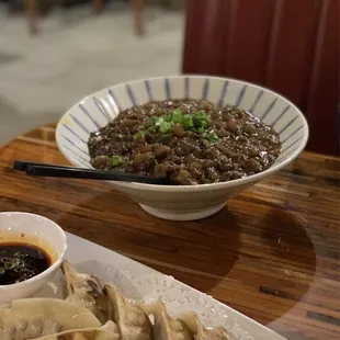 a plate of dumplings and a bowl of sauce