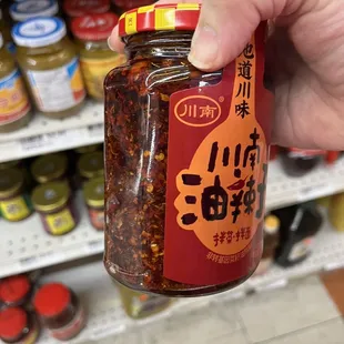 a hand holding a jar of food